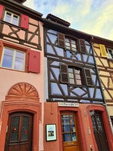 an old building with a half timbered at Hotel Arc-En-Ciel Colmar Contact Hotel in Colmar