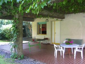 un patio con mesa, sillas y un árbol en Villa Arya Casa Vacanza, en Riposto