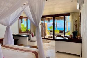 a bedroom with two beds and a view of the ocean at The Beach Tulum in Tulum