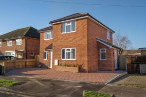 a red brick house with a large driveway at Mill Road Apartment First Floor in Crawley