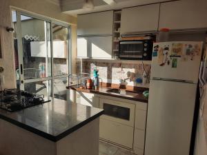 cocina con nevera blanca y encimera en Charmosa casa em condominio com quintal en São Paulo