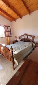 Cabañas Don Nico في San José de la Dormida: غرفة نوم بسرير خشبي في غرفة