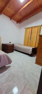San José de la Dormida的住宿－Cabañas Don Nico，一间卧室设有两张床和木制天花板