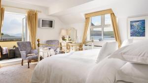 una camera con letto, scrivania e finestre di Heatons Guesthouse a Dingle