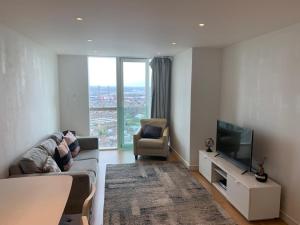 a living room with a couch and a tv and a chair at GRAND SERVICED APARTMENTS***** in Croydon