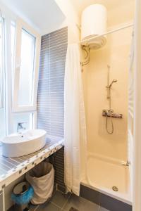 ein Badezimmer mit einem Waschbecken, einer Badewanne und einer Dusche in der Unterkunft Apartment Red Bike in Zagreb