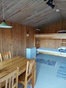 a wooden cabin with a dining table and a bunk bed at Hästveda Vandrarhem och Stugor in Hästveda