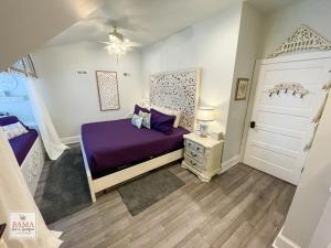 1 dormitorio con cama morada y puerta blanca en Bama Bed and Breakfast - Wisteria Suite, en Tuscaloosa