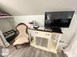 a room with a desk with a tv and a chair at Bama Bed and Breakfast - Wisteria Suite in Tuscaloosa