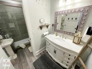 y baño con lavabo y espejo. en Bama Bed and Breakfast - Wisteria Suite, en Tuscaloosa