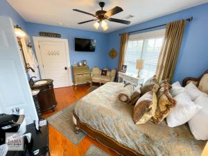 a bedroom with a bed with blue walls and a ceiling fan at Bama Bed and Breakfast - Chimes Suite in Tuscaloosa
