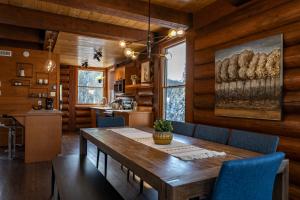 a dining room with a wooden table and blue chairs at 4-Bedroom Chalet Fraternite in Lac-Superieur Tremblant in Lac-Superieur