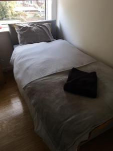 a bed with a black pillow sitting on top of it at Modern property close to Aintree Hospital & Motorways in West Derby