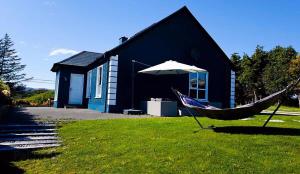 a hammock in the grass in front of a house at Luxury Wild Atlantic Way accommodation with sea views and free wifi in Bruckless