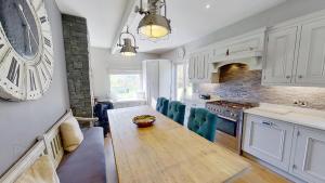 a kitchen with a wooden table and blue chairs at Luxury Wild Atlantic Way accommodation with sea views and free wifi in Bruckless
