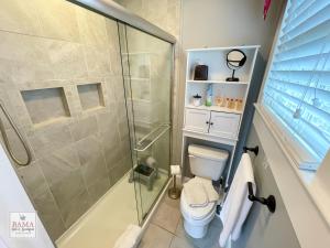 uma casa de banho com um WC e uma cabina de duche em vidro. em Bama Bed and Breakfast - Sweet Home Alabama Suite em Tuscaloosa