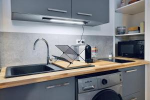a kitchen with a sink and a dish drying rack at Touche "majordomesque" #CL in Grenoble