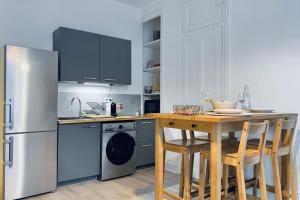 a kitchen with a refrigerator and a table with chairs at Touche "majordomesque" #CL in Grenoble