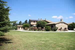a large stone house with a grass yard at Agriturismo il Cicaleto in Cannara