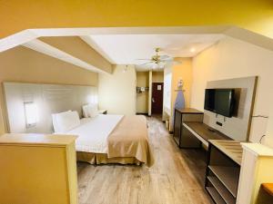 ein Hotelzimmer mit einem Bett und einem Flachbild-TV in der Unterkunft America's Best Inns Flowood in Flowood