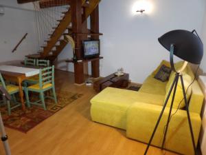 ein Wohnzimmer mit einem gelben Sofa und einem Tisch in der Unterkunft Apartman Matea 4 in Gospić