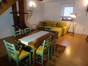 ein Wohnzimmer mit einem Tisch, Stühlen und einem gelben Sofa in der Unterkunft Apartman Matea 4 in Gospić
