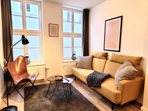 a living room with a couch and two windows at Das Stader Quartier in Stade