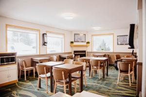 a dining room with tables and chairs and windows at Super 8 by Wyndham Revelstoke BC in Revelstoke