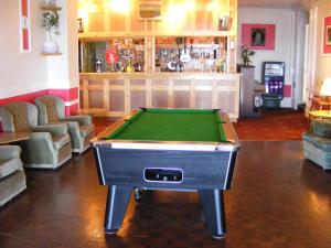 a pool table in a room with a bar at Trevelyan Hotel in Douglas