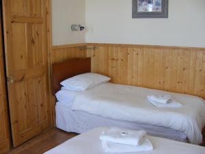 two beds in a room with two white towels at Trevelyan Hotel in Douglas