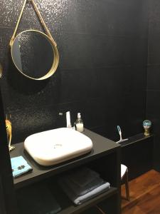 a bathroom with a white sink and a mirror at Chez Cathy et Léo in Dinan