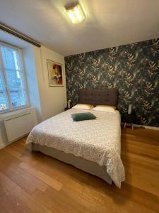 sypialnia z łóżkiem i dużym oknem w obiekcie Chez Cathy et Léo w mieście Dinan