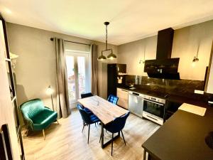 a kitchen with a table and chairs in a room at 3 pièces de rêve à menton in Menton