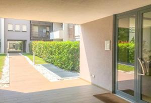 zewnętrzny widok na budynek z żywopłotem w obiekcie CaseOspitali - Casa La Vela, raffinato bilocale con balcone w mieście Cernusco sul Naviglio