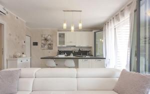 salon z białą kanapą i kuchnią w obiekcie CaseOspitali - Casa La Vela, raffinato bilocale con balcone w mieście Cernusco sul Naviglio