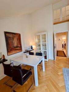 een witte eetkamer met een witte tafel en stoelen bij Tallskog - Dein Apartment am Naturstrand Hohen Wieschendorf in Hohenkirchen