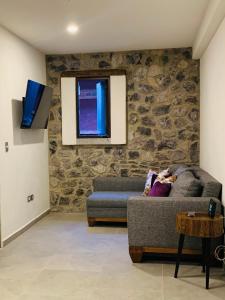 a living room with a stone wall and a couch at Atrani in Santeagueda +26 photos