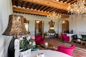 ein Wohnzimmer mit einem Tisch und rosa Stühlen in der Unterkunft Villa La Preziosa in Lucca