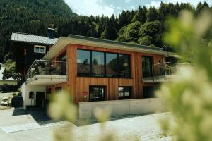 a house with large glass windows and a balcony at Haus Galgenul in Sankt Gallenkirch