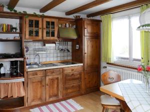 cocina con armarios de madera, fregadero y mesa en Gästehaus Lickert Familie Dreher, en Hinterzarten