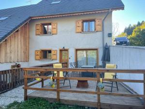 Allemond - Restful 2 bed apartment for ski, cycle & family في أليمونت: منزل به سطح خشبي مع طاولة وكراسي