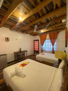 une chambre d'hôtel avec deux lits et une table dans l'établissement Don Panchon y Maruxa, à Holbox