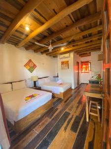 two beds in a room with wooden ceilings at Don Panchon y Maruxa in Holbox Island