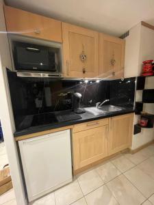 a kitchen with a sink and a microwave at L'aiguille de L'M in Chamonix-Mont-Blanc