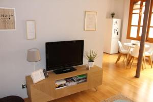 sala de estar con TV de pantalla plana sobre una mesa en La Casa de Sillería en Toledo