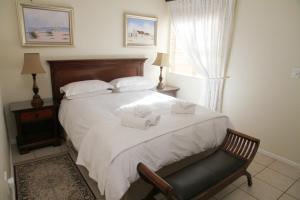 1 dormitorio con 1 cama con 2 toallas en Whispering Whale, en Jacobs Bay