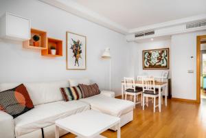 een woonkamer met een witte bank en een tafel bij ALAIA PLAYA GRAN TERRAZA by AlohaMalaga in Málaga