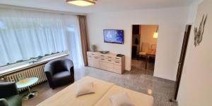 a living room with a table and a chair and a television at Bonsai-Apartment II in Bad Pyrmont