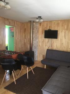ein Wohnzimmer mit einem Sofa und einem Tisch in der Unterkunft Cabañas Tinajas hidromasaje Chanlelfu in Puyehue