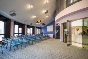a conference room with blue chairs in a building at Hotel sirena in Cesenatico
